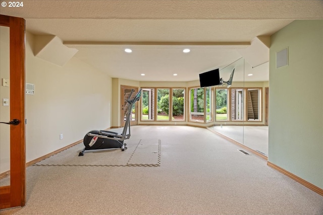 workout area with carpet floors and a textured ceiling