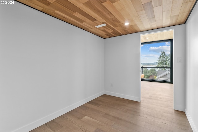 empty room featuring light wood-type flooring and wood ceiling