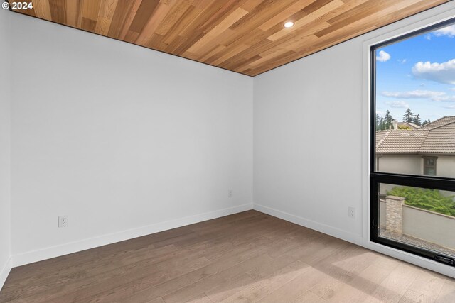 empty room featuring light hardwood / wood-style flooring and wood ceiling