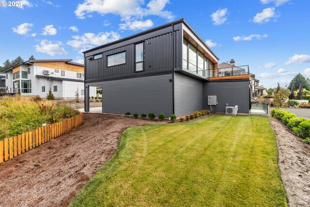 rear view of house featuring a balcony, a lawn, and cooling unit