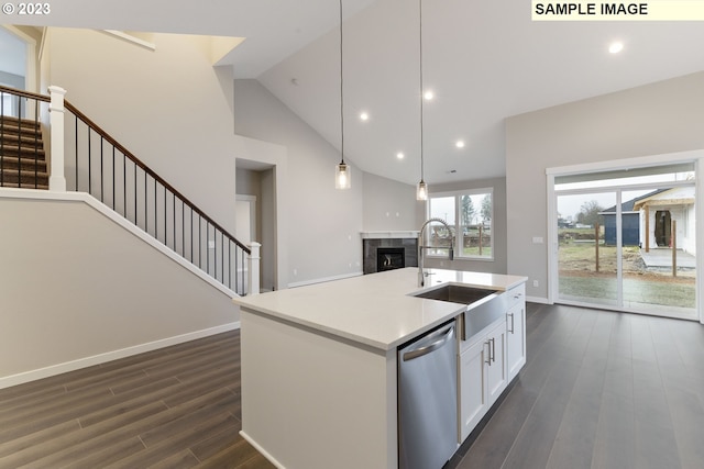 kitchen featuring pendant lighting, white cabinets, a center island with sink, stainless steel dishwasher, and dark hardwood / wood-style flooring