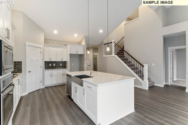 kitchen with white cabinetry, sink, an island with sink, pendant lighting, and appliances with stainless steel finishes