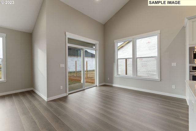 unfurnished living room featuring high vaulted ceiling and wood-type flooring