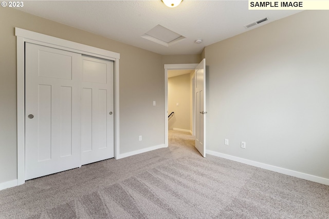 unfurnished bedroom with light carpet and a closet