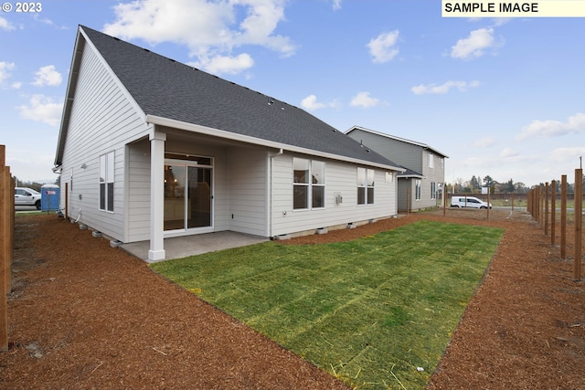 rear view of property featuring a patio area and a yard