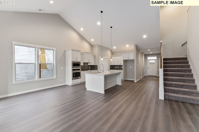 kitchen with pendant lighting, a center island with sink, sink, dark hardwood / wood-style floors, and stainless steel appliances