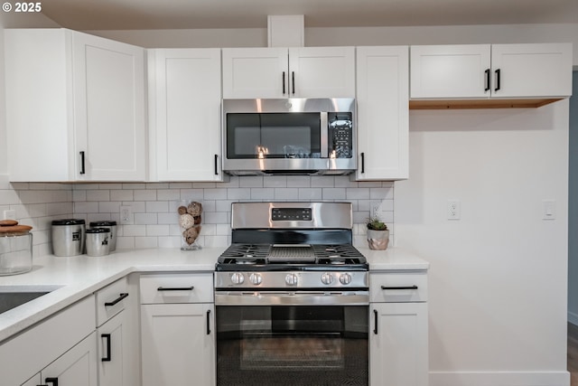 kitchen with appliances with stainless steel finishes, decorative backsplash, and white cabinetry