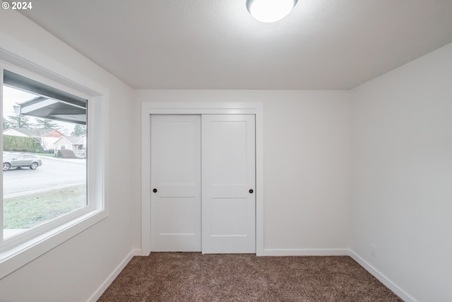 unfurnished bedroom with carpet flooring and a closet