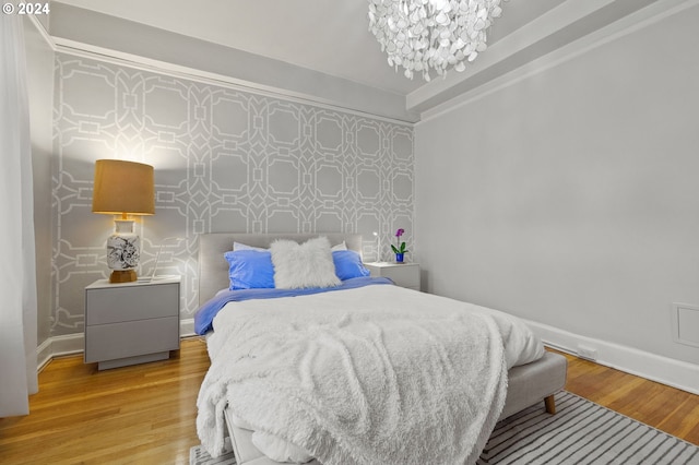 bedroom featuring a notable chandelier and wood-type flooring