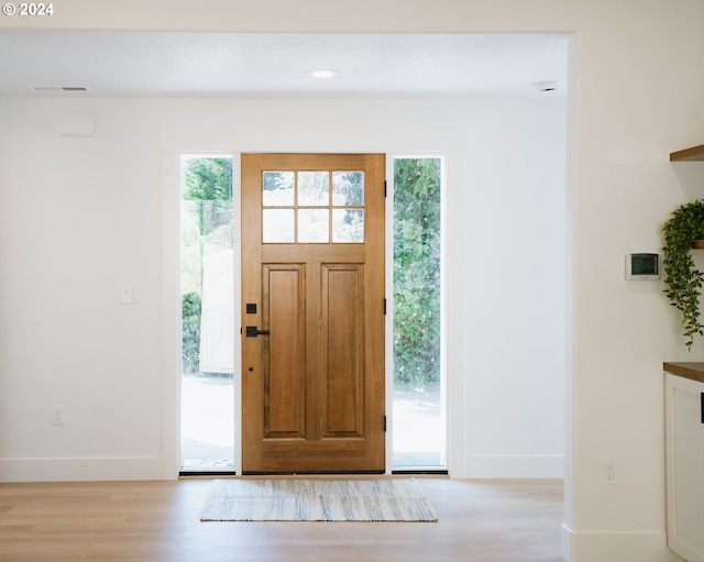 foyer entrance with light wood-type flooring, visible vents, baseboards, and recessed lighting