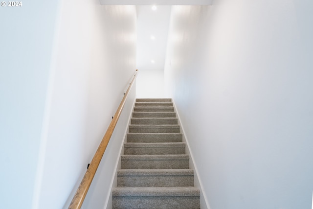 stairway featuring carpet flooring and baseboards