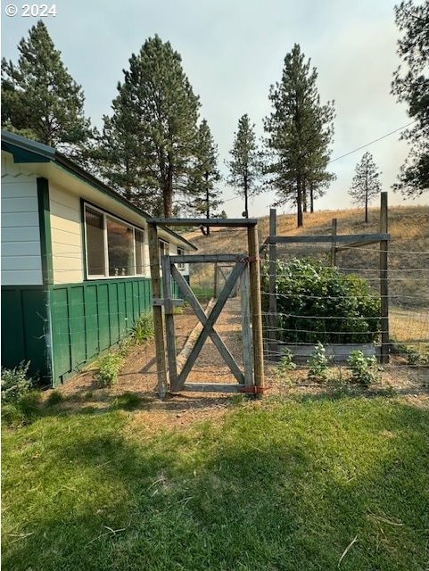 view of gate with a lawn