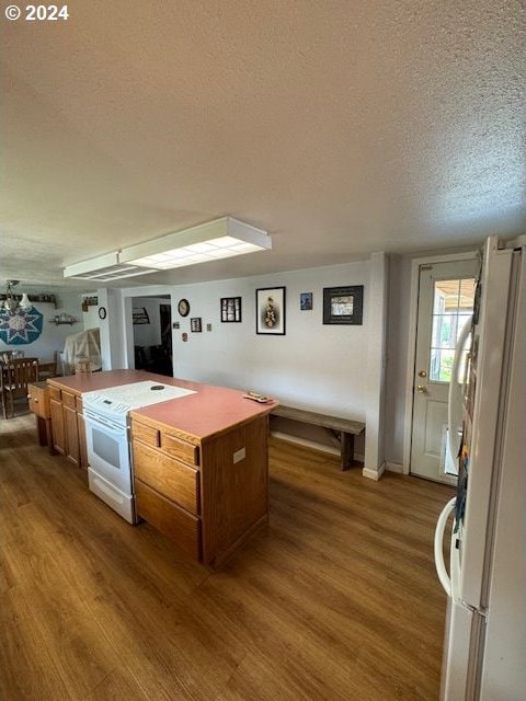 kitchen with white appliances, dark hardwood / wood-style flooring, and a textured ceiling