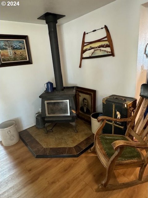 living area featuring wood-type flooring and a wood stove