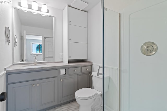 bathroom with tile patterned flooring, vanity, toilet, and walk in shower