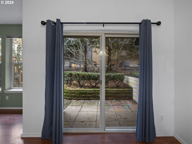 doorway to outside with dark hardwood / wood-style floors and a healthy amount of sunlight