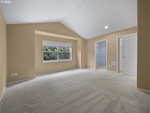 carpeted spare room featuring lofted ceiling