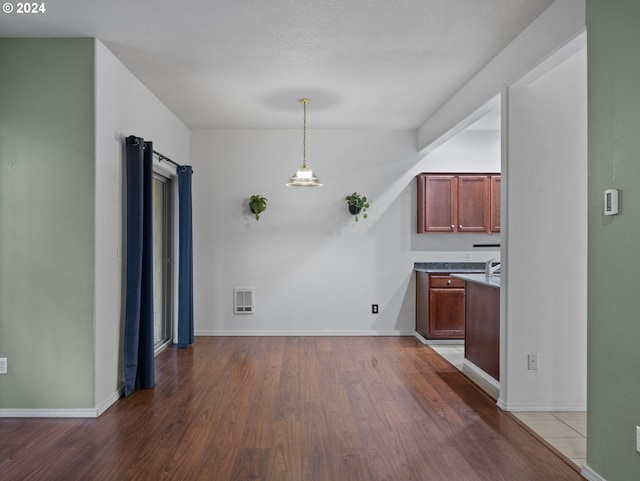 kitchen with wood-type flooring and pendant lighting