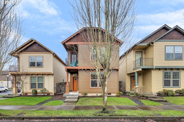 craftsman inspired home featuring a balcony and a front lawn