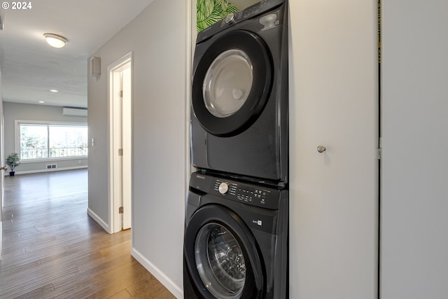 washroom with light wood-type flooring and stacked washer and dryer