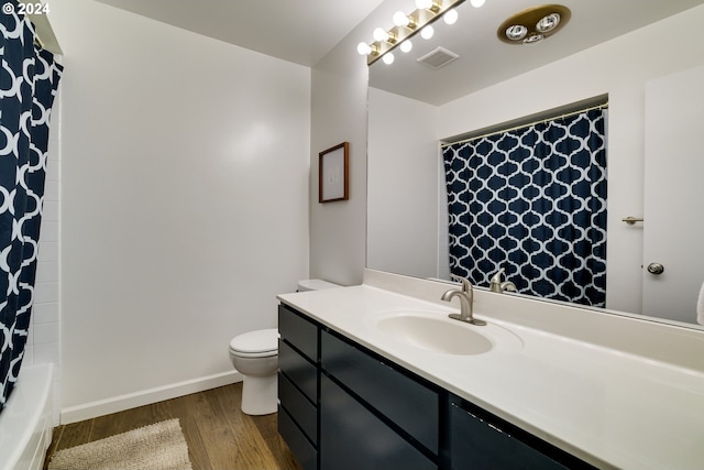 full bathroom with vanity, hardwood / wood-style floors, toilet, and shower / bath combo