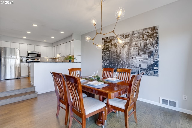 dining space with an inviting chandelier and wood-type flooring