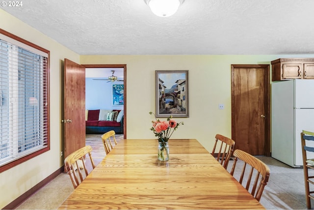 dining space with a textured ceiling, ceiling fan, and light tile patterned floors