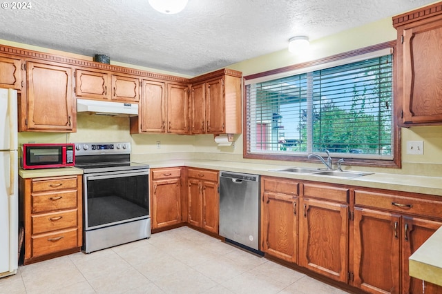 kitchen with a textured ceiling, stainless steel appliances, and sink