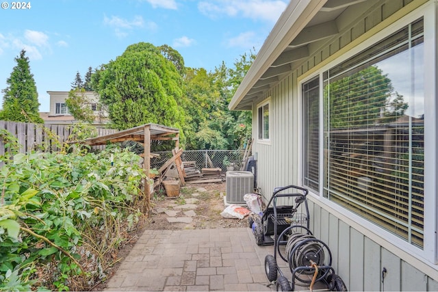 view of patio with cooling unit and a deck