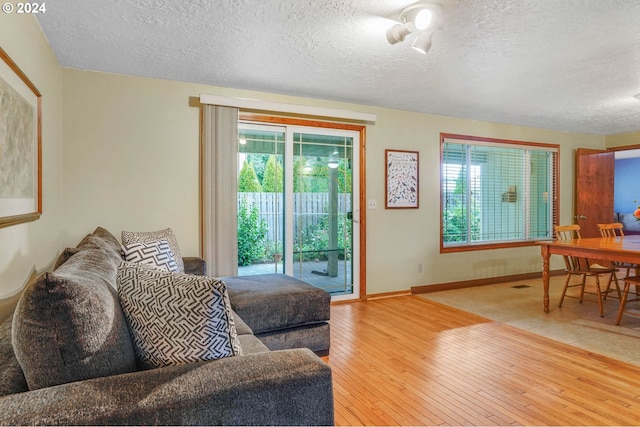 living room with a textured ceiling and light hardwood / wood-style floors