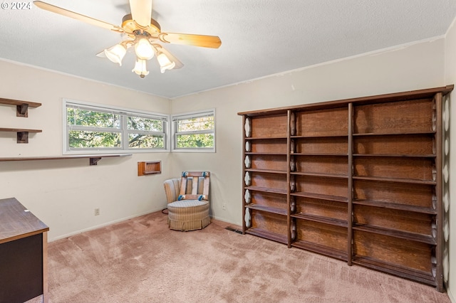 unfurnished room with a textured ceiling, light colored carpet, and ceiling fan