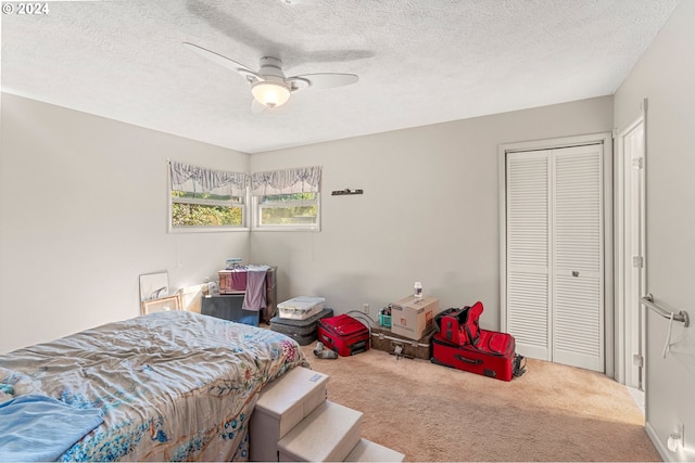 bedroom with a closet, a textured ceiling, carpet, and ceiling fan