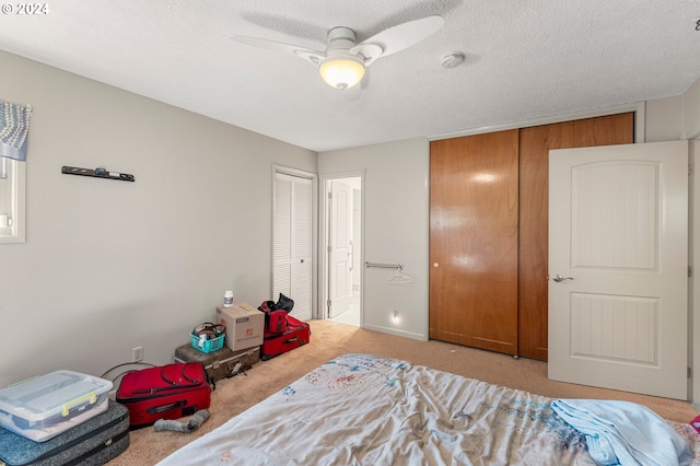 carpeted bedroom with a textured ceiling and ceiling fan