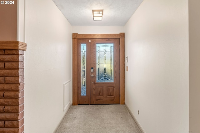 entryway with light carpet and a textured ceiling