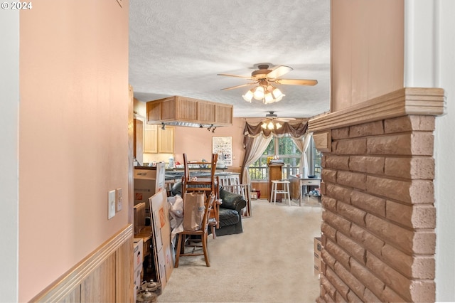 interior space featuring a textured ceiling, light colored carpet, and ceiling fan