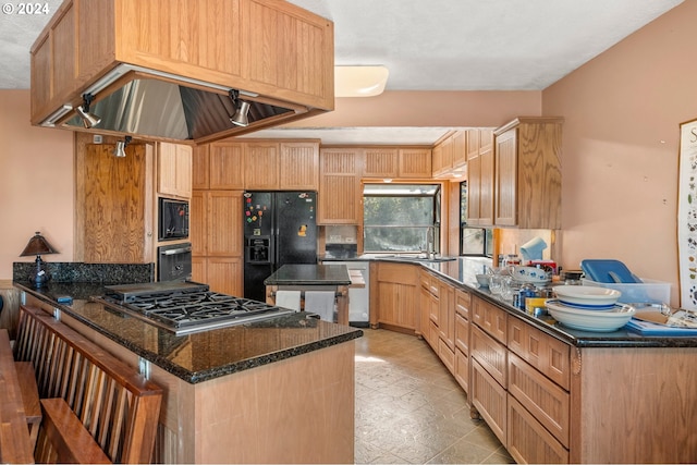 kitchen with black appliances, a textured ceiling, dark stone counters, custom range hood, and light brown cabinets