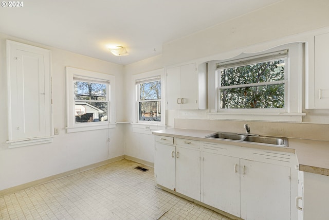 kitchen featuring white cabinetry and sink