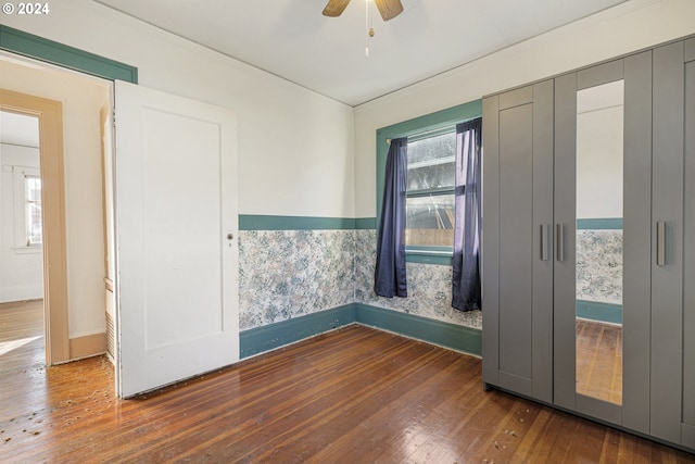 spare room featuring ceiling fan, a healthy amount of sunlight, and wood-type flooring