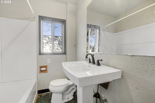 bathroom featuring bathtub / shower combination and toilet