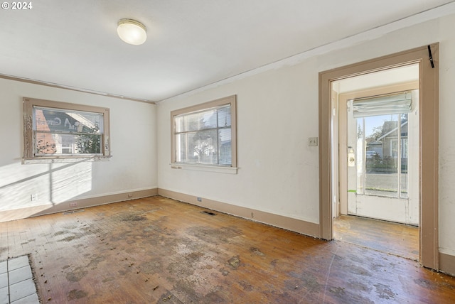 unfurnished room featuring a healthy amount of sunlight and ornamental molding