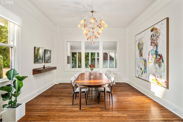 dining room featuring ornamental molding, hardwood / wood-style flooring, a wealth of natural light, and a notable chandelier