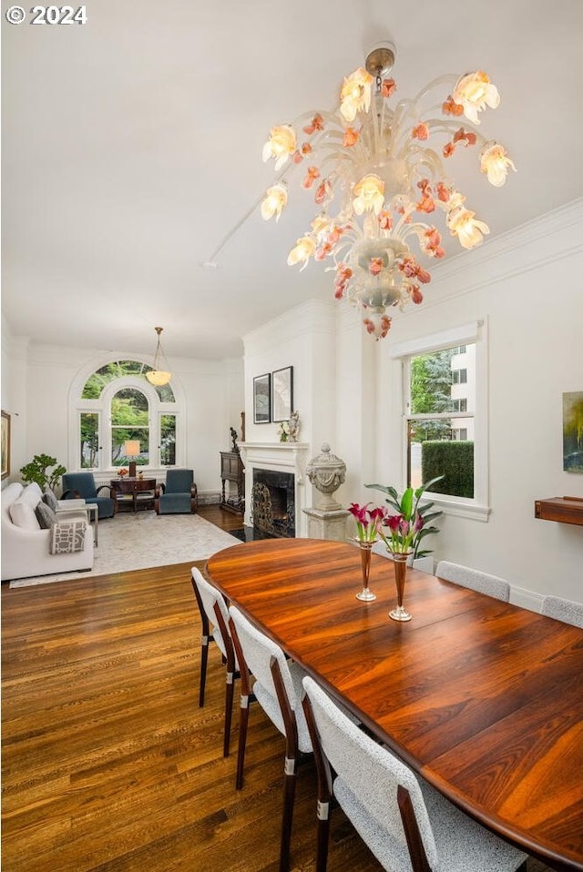 dining space featuring a fireplace, crown molding, and hardwood / wood-style floors