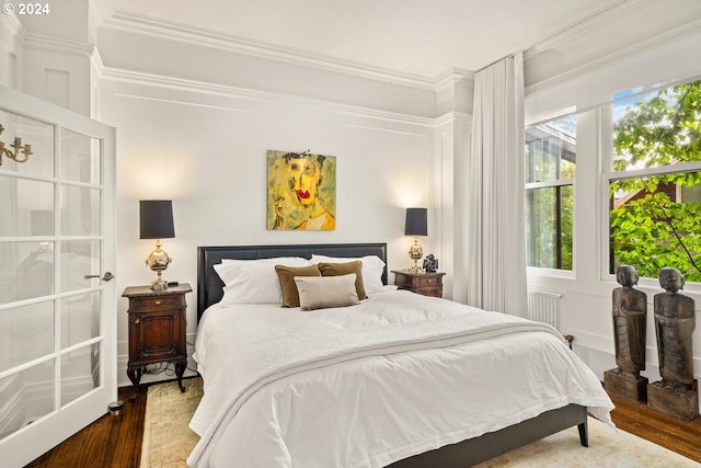 bedroom featuring dark wood-type flooring, radiator, and ornamental molding