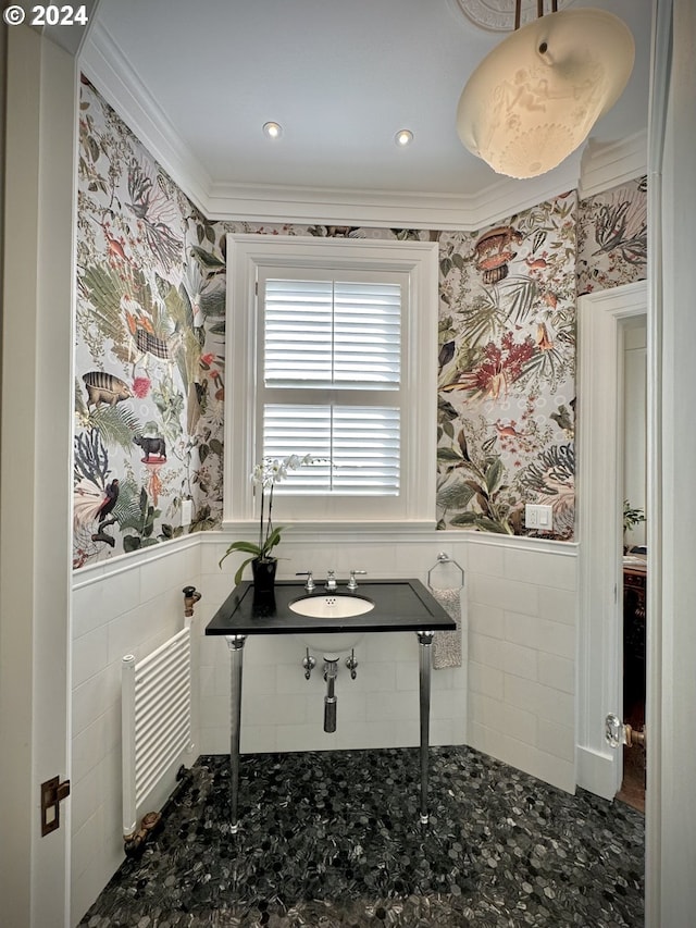 bathroom featuring crown molding and tile walls