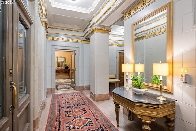 hallway with ornamental molding, tile walls, hardwood / wood-style flooring, and ornate columns