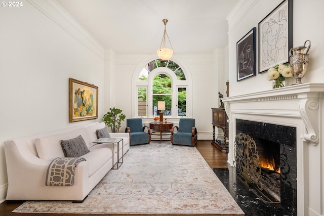 living room with a premium fireplace, ornamental molding, and dark wood-type flooring