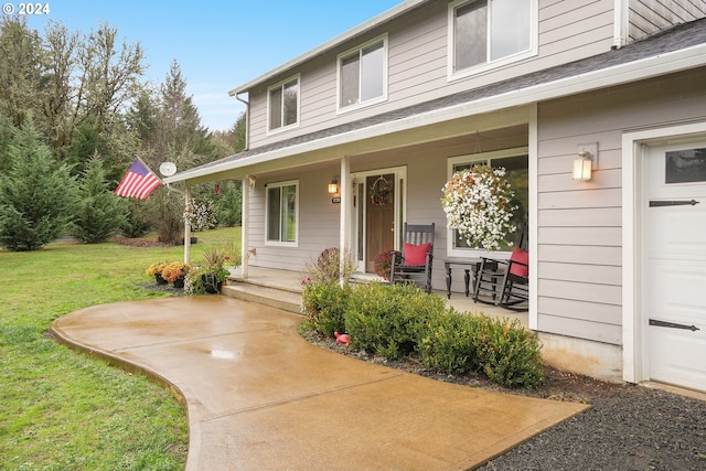 entrance to property with a lawn and covered porch