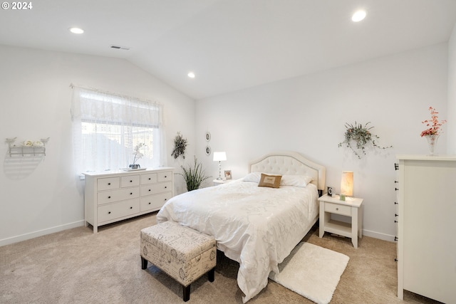 bedroom featuring light colored carpet and vaulted ceiling