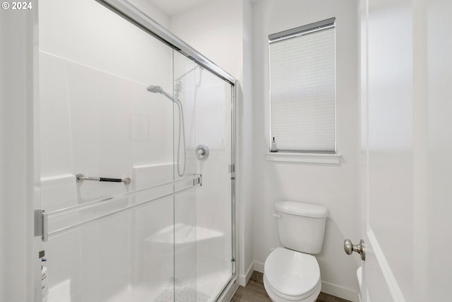 bathroom featuring walk in shower, wood-type flooring, and toilet