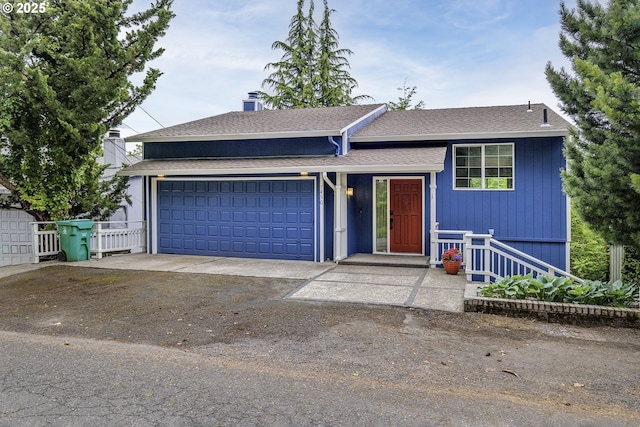 7450 SW 17th Dr, Portland, OR 97219 - tri-level home featuring a garage, roof with shingles, and driveway